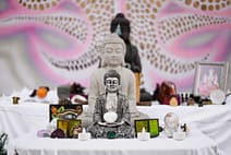 gallery-5 A detailed view of a Buddhist altar featuring multiple Buddha statues and spiritual objects.